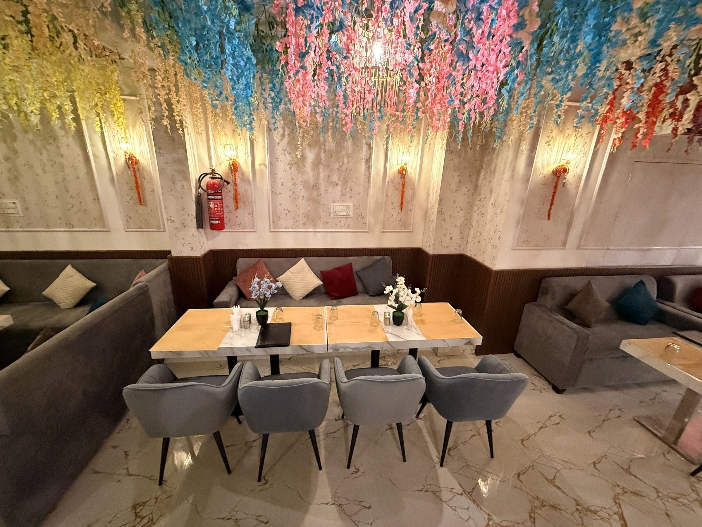 The Silver Spoon dining room beneath a canopy of hanging flowers and a glowing chandelier